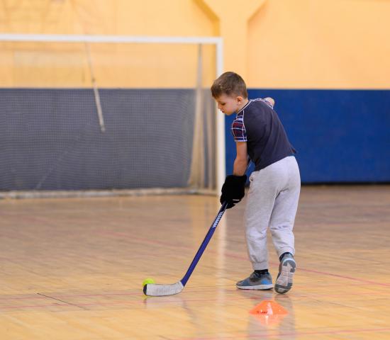child playing floor hockey
