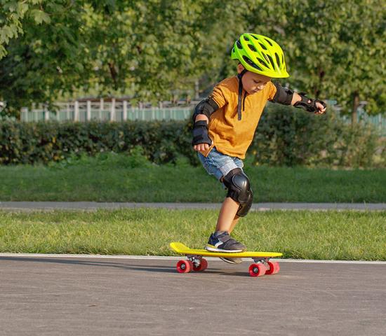 child wearing safety equipment practicing to skateboard