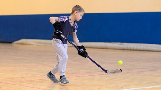 child playing floor hockey