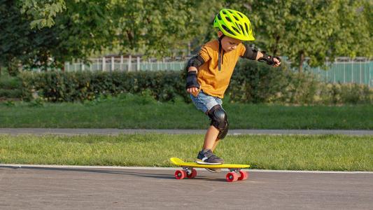 child wearing safety equipment practicing to skateboard