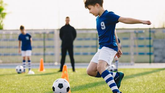 kid kicking soccer ball